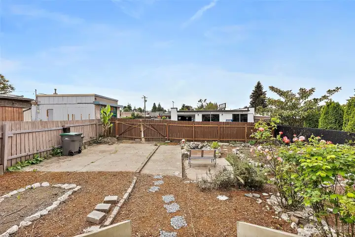 Fully fenced backyard offers alley access, garden space, and endless potential for outdoor living, parking, or entertaining.