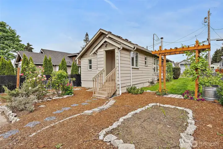 Rear exterior highlights charming architecture, landscaped pathways, and inviting outdoor spaces designed for relaxation.