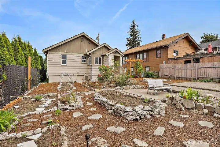 Beautifully landscaped backyard showcases a tranquil water feature, garden paths, and abundant space for outdoor enjoyment.