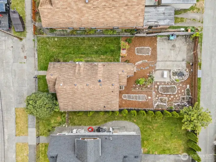 Aerial view showcases the full property layout, alley access, expansive backyard, and thoughtfully designed outdoor living spaces.