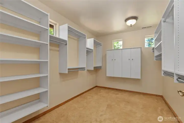 Bright walk-in closet with windows streaming in natural light.