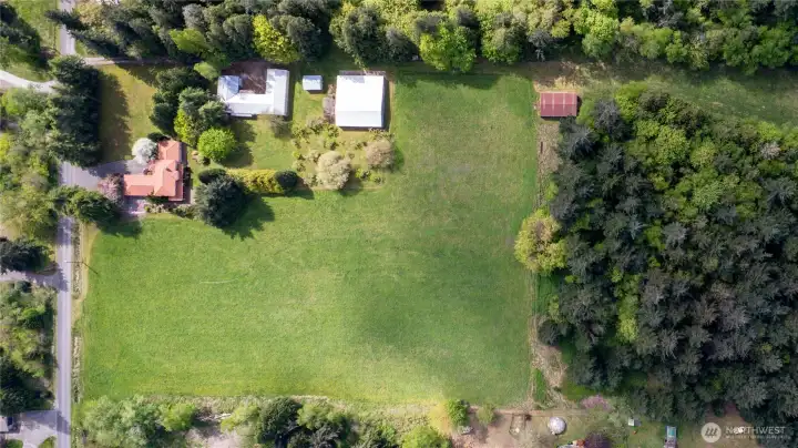 Aerial view of the property, including the wooded area. Lot Dimension: 1293 X 491 X 1297 X 493