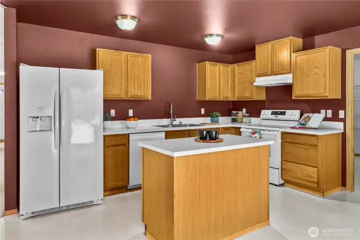 Large kitchen includes center island, eat-in area, and slider to the fully-fenced backyard.