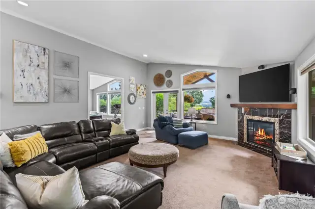 Large living room off the kitchen has a cozy gas fireplace.  It also leads out the the covered patio that feels like it is an extension of the house and also leads to the rec room around the corner where these is a wet bar and pool table.