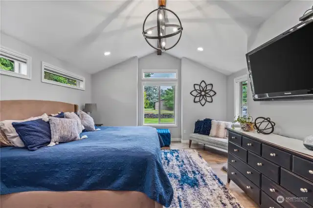Spacious Primary Bedroom with lots of natural lighting and wood beam across the ceiling.