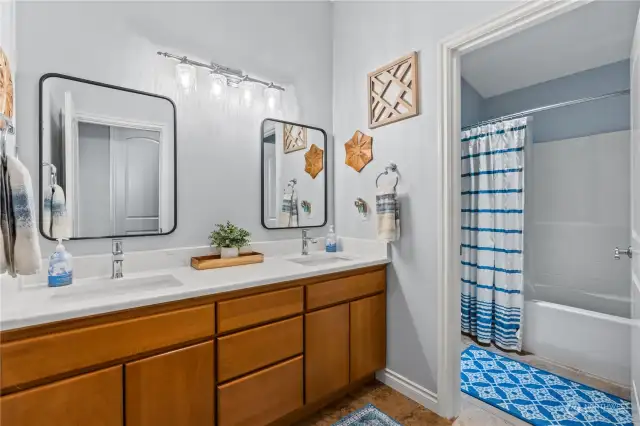 Full bathroom located next to Bedroom 1 and 2 has double vanities as well as an enclosed area with the toilet and tub/shower.