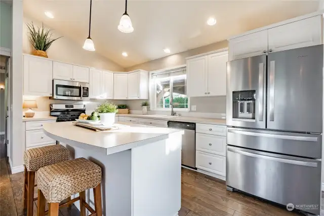 Kitchen with SS appliances, gas stove and large island.