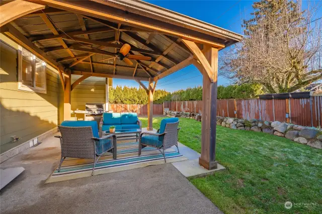 Backyard patio and gazebo. Decorative metal fence and rock beds give this yard character.