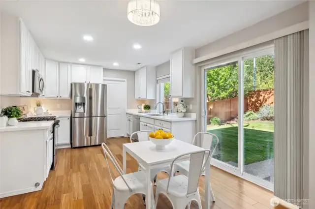 Open-concept kitchen with sliding door to fully-fenced backyard.