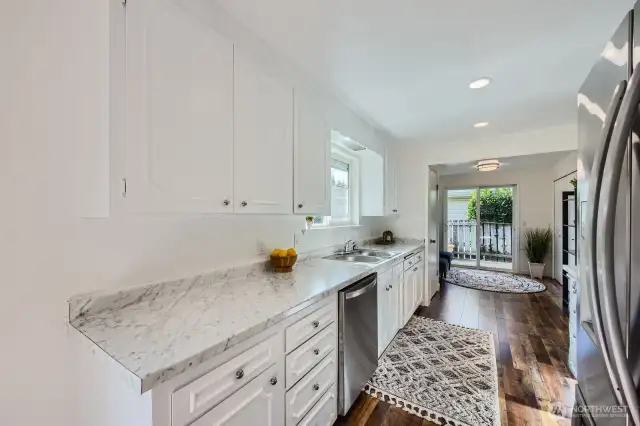 Bright & modern kitchen boasts Frigidaire Stainless Steel appliances, updated hardware, marblesque countertops and, stainless double bowl sink
