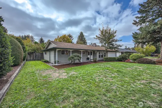 Lots of level, grassy land in front with seasonal shrubs, bushes, lined edging & flower bed.  This generous front yard creates a nice buffer of privacy & distance from the street