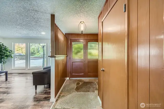 This home has been updated, while some of the mid-century-modern design has been preserved. Beautiful slate flooring brings nature indoors to the good-sized foyer with antique chandelier, coat closet & decorative natural wood slatted wall allows an open feel into the front living room