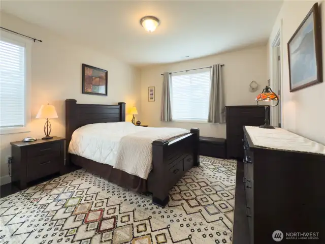The primary bedroom is spacious and has plenty of light thanks to an added window and custom blinds.