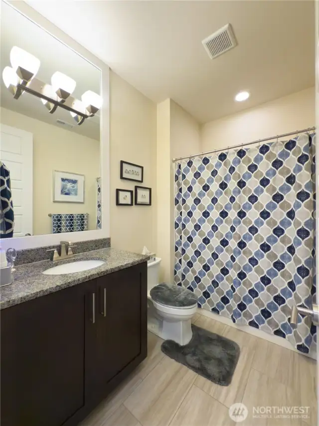 The guest bathroom has granite countertops and tile flooring. I like this detail, it elevates the entire house.