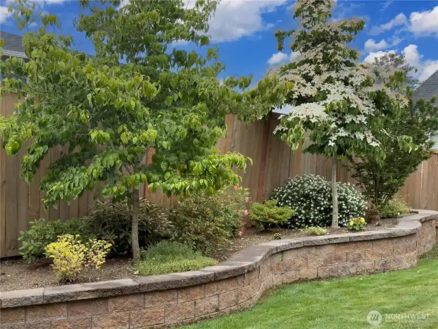 The yard includes a custom-raised garden area for herbs, vegetables, and flowers.