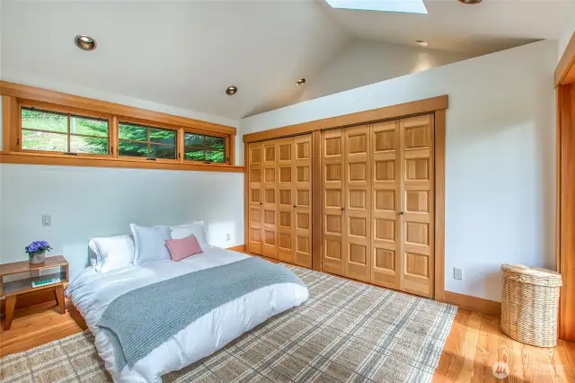 The primary bedroom features generous closet space and showcases warm fir wood floors.    The primary bedroom features generous closet space and showcases warm fir wood floors."
