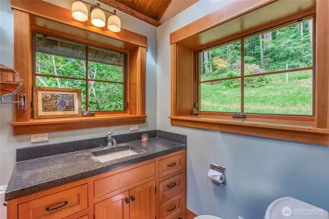 The three-quarter bathroom features a concrete countertop atop a custom-built fir vanity.