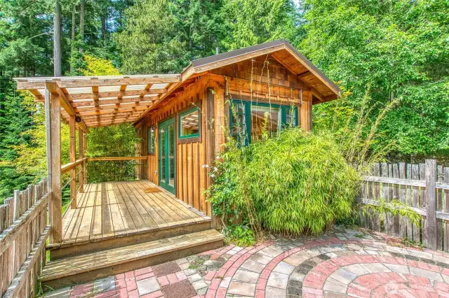 The small retreat is fenced with a brick patio and a large deck overlooking the grounds.