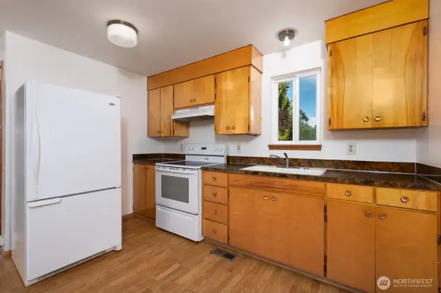 Laminate flooring in the kitchen and a nice view outside.