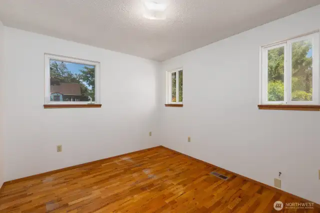 Second bedroom has lots of windows resulting in great lighting! This room also features hardwood floors.