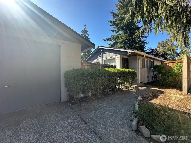 From garage to front door, this charming walkway with partial privacy fencing makes every arrival feel welcoming.