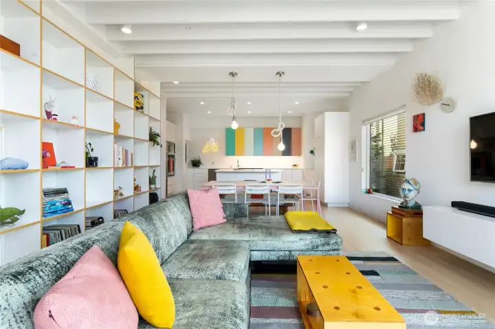 The show stopping second floor living space includes soaring ceilings with exposed rafters and the continuation of the two story book case.