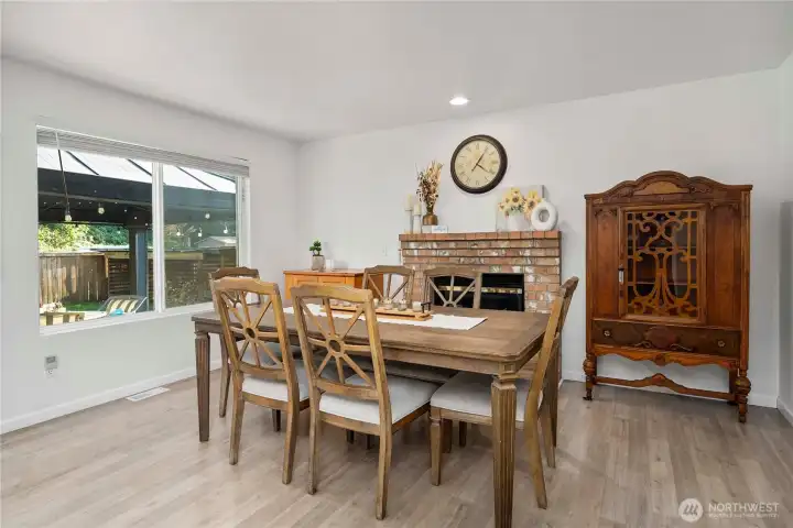 Second living area currently utilized as a dining room features natural light and a wood fireplace