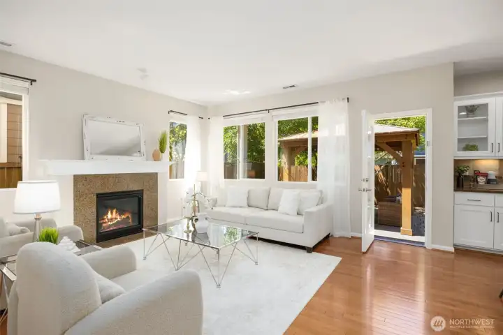 Rich hardwoods through the main floor into a cozy living room anchored by a warm fireplace.