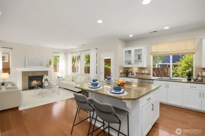 The chef’s kitchen featuring granite countertops, full_height backsplash, designer cabinetry with glass inserts and under cabinet lighting.