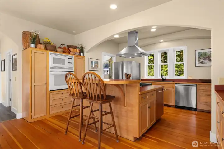 Spacious kitchen with custom cabinetry, new induction stove, refrigerator, dishwasher, farmhouse sink and fixtures.