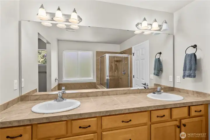 Vanity, shower, and tub area beautifully reflected through the mirror, enhancing the sense of space and light