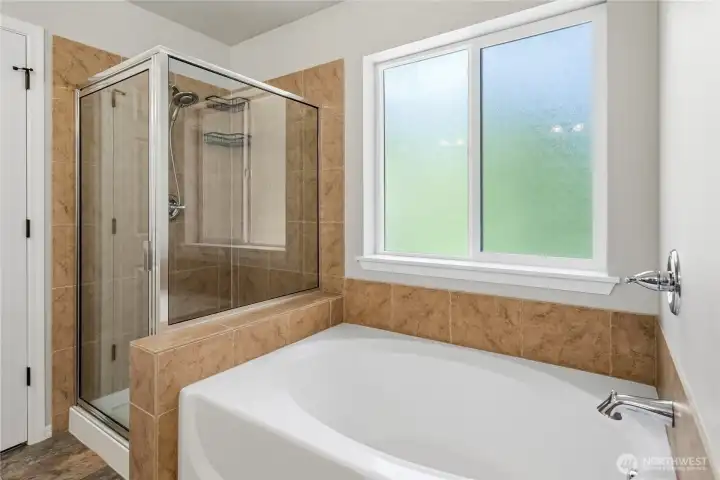 Primary bathroom featuring a soaking tub and separate standalone shower