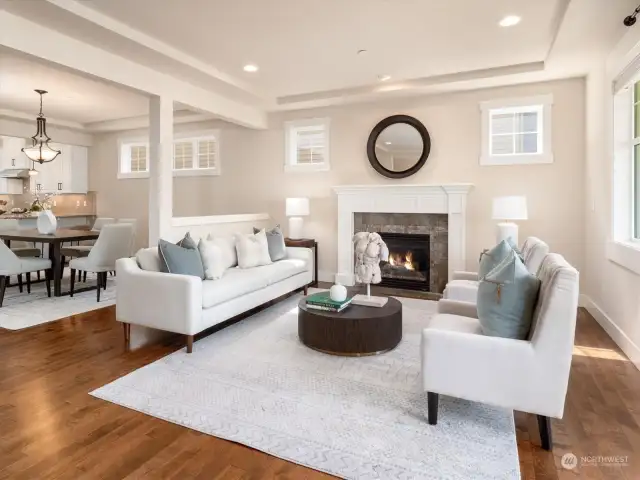 High recessed ceilings with gas fireplace wrapped in white mantle creates inviting ambiance, prefect for relaxation or cozy gatherings.