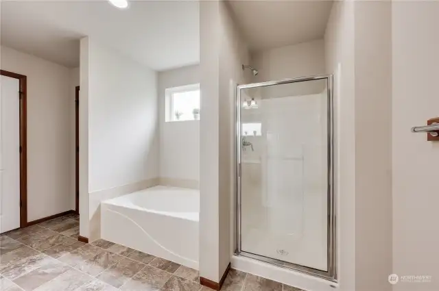 Primary bathroom features soaking tub and separate shower