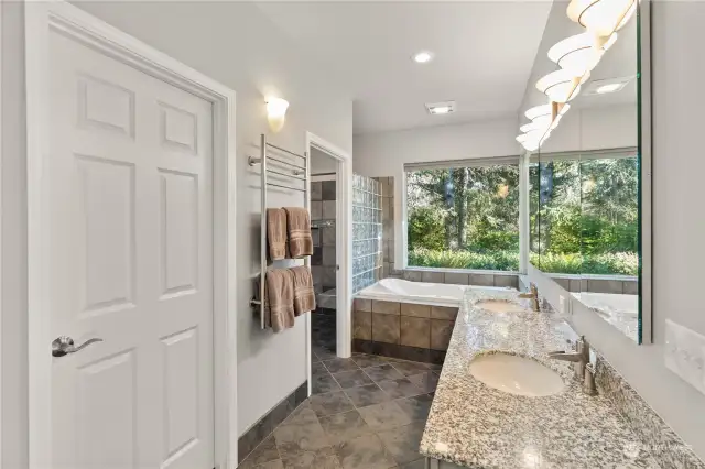 Primary bathroom with double sinks, jetted tub, heated towl rack