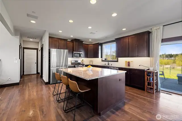 Beautiful cabinetry, sleek countertops, and ample storage make the kitchen both functional and stylish. The door to the left leads to the attached garage.