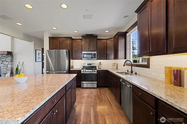 Stainless steel appliances and a large center island complete this well-equipped kitchen.