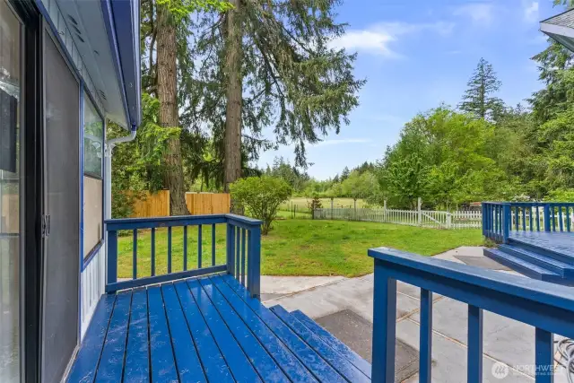 View from one of two southern decks and a small walk to the barn past the white picket fence.