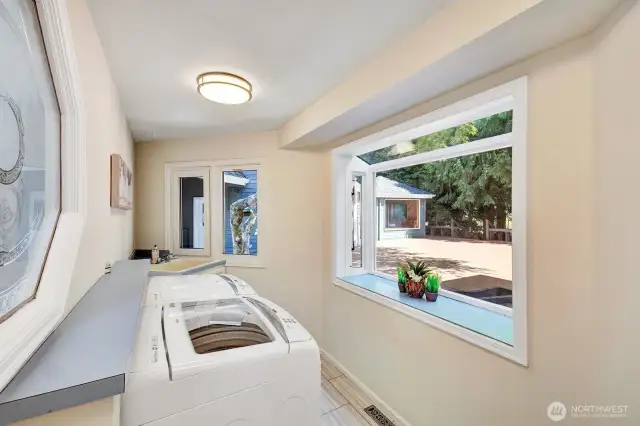 Laundry room located off of a corridor with storage closets