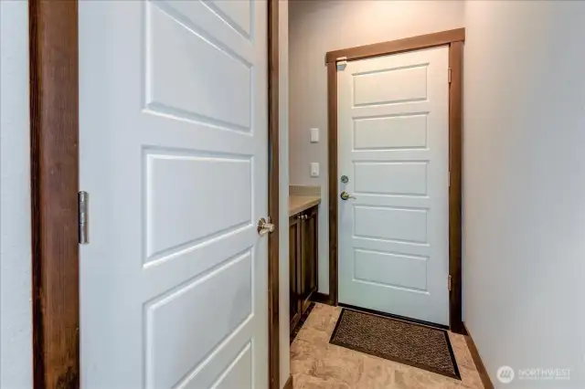 A mudroom or catch-all space with coat closet coming in from garage.