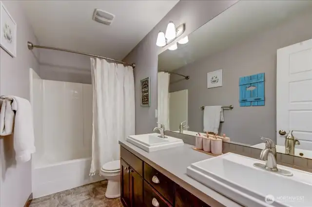 Main bath with dual sinks, located near the auxiliary bedrooms.