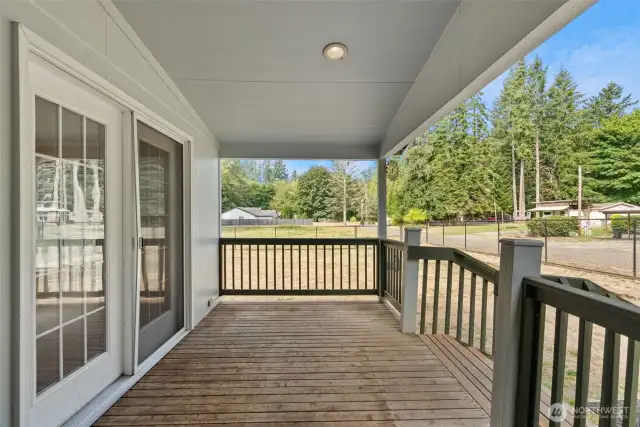 Relax on the covered deck while overlooking the backyard and beyond—the property extends past the fence, offering even more space to enjoy. Perfect for year-round outdoor living with room to spread out and take in the peaceful setting.