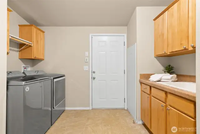 This laundry room makes everyday chores easier with plenty of cabinet storage, a sink, and a spot to hang clothes. Conveniently connected to the garage, it’s the perfect drop zone for busy days.