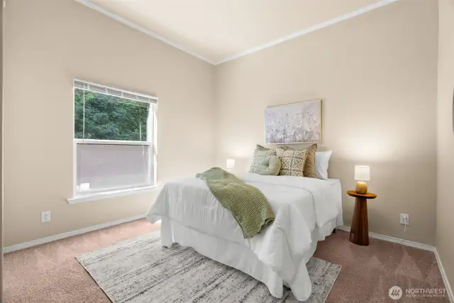 The third bedroom provides a cozy retreat with neutral tones and a large window that brings in natural light.