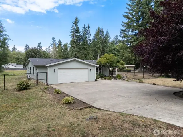 A spacious driveway and attached two-car garage provide plenty of parking and convenience, all set within a partially fenced property surrounded by nature. Welcome home to comfort, privacy, and room to grow.