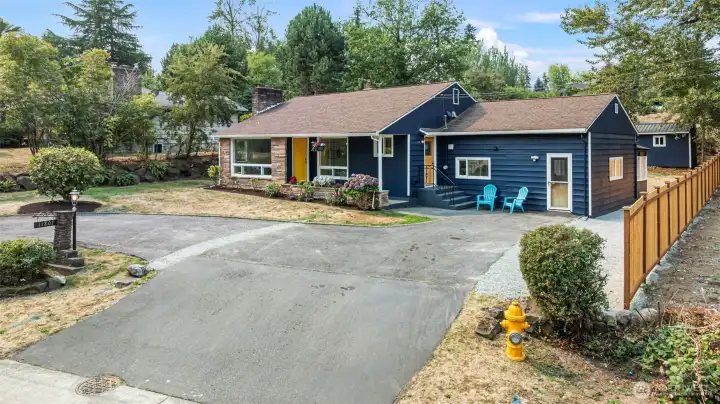 Fresh exterior paint, Goldfinch-yellow door, and side-entry seating add personality and welcome.