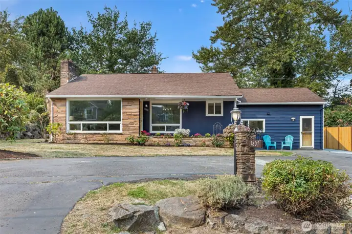 Classic mid-century charm with sandstone planter beds, layered textures, and vinyl windows with future upgrade potential.