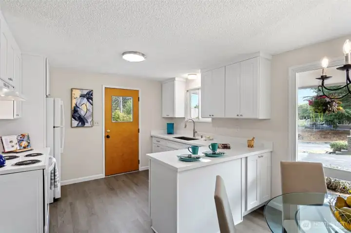 Beautifully reimagined kitchen with quartz countertops, soft-close cabinetry, and a peninsula for added storage and bar seating.