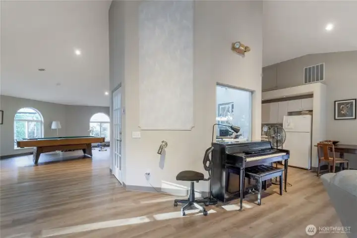 Clubhouse piano and a peek to the kitchen beyond. This space can be used by the community as well as reserved for private gatherings.
