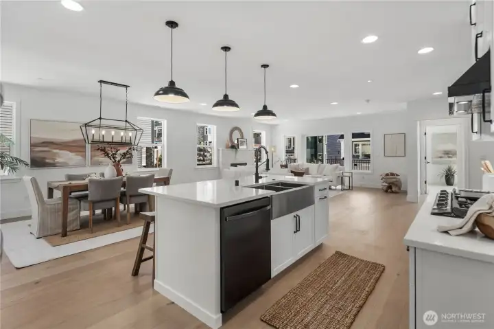 Kitchen & Living Flow: Expansive island with farmhouse sink and modern fixtures overlooks the dining and great room. This open-concept design highlights natural light and creates effortless flow for entertaining or quiet evenings at home.  Staged photos are of the model home of the same floorplan within the Foxmoore community and are for visualization purposes only. Colors, finishes, and layout can and will vary.